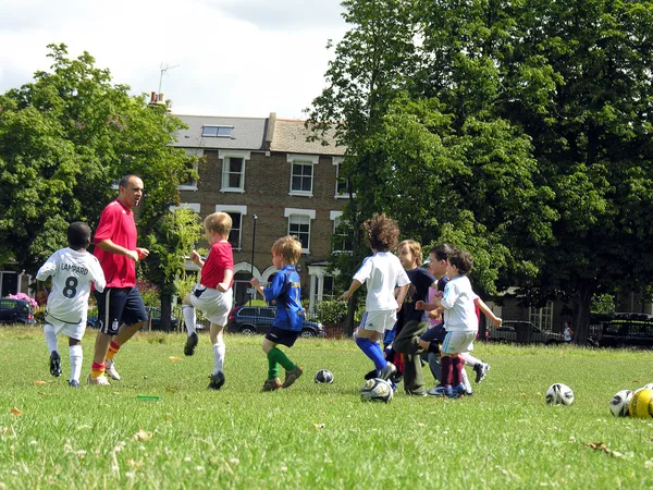 Çocuklar parkta futbol oynuyor. — Stok fotoğraf