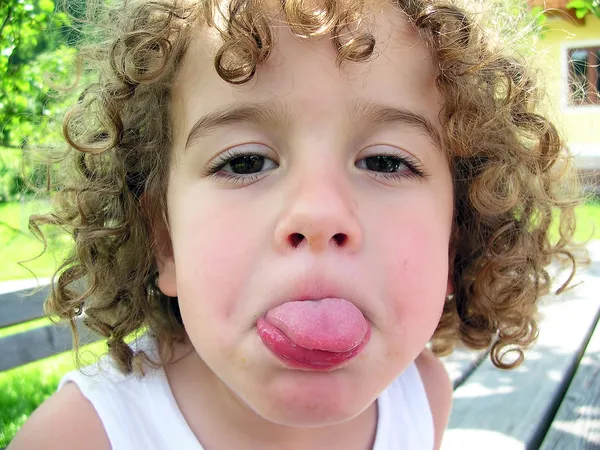 Pequeño niño sacando la lengua — Foto de Stock