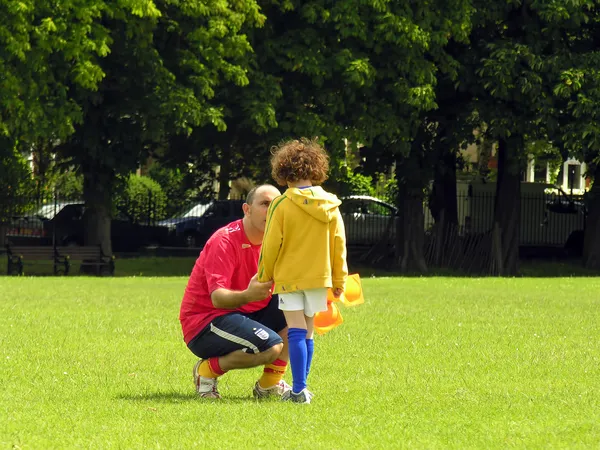 Entrenador de fútbol está hablando con un pequeño jugador —  Fotos de Stock