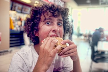 genç oğlan onun hamburger yiyor