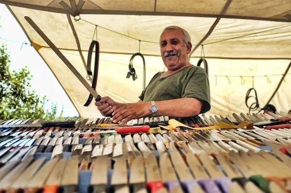 Knife seller at his outdoor market stall — Stock Photo, Image