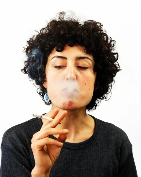 Jovem mulher sopra fumaça — Fotografia de Stock