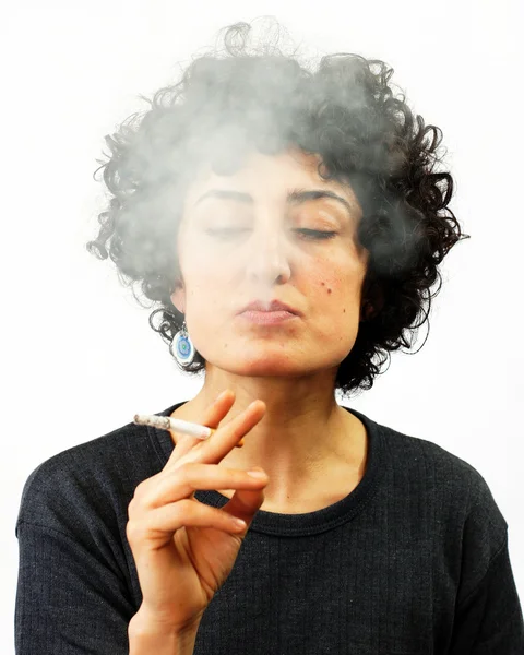 Mujer joven sopla humo — Foto de Stock