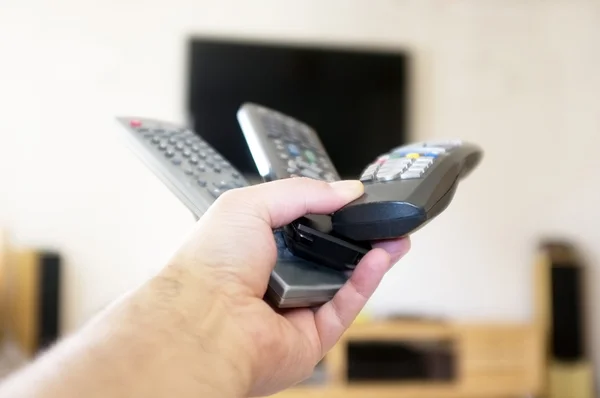 Three remote controls in one hand — Stock Photo, Image