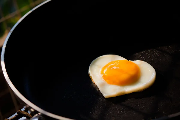 Heart-shaped fried egg on frying pan — Stock Photo, Image