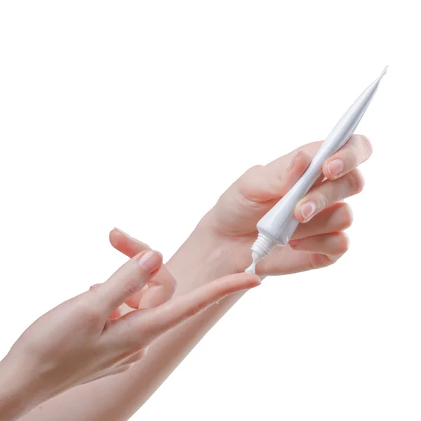 Изолированное изображение девушка наносит белый крем от трубки до указательного пальца — стоковое фото