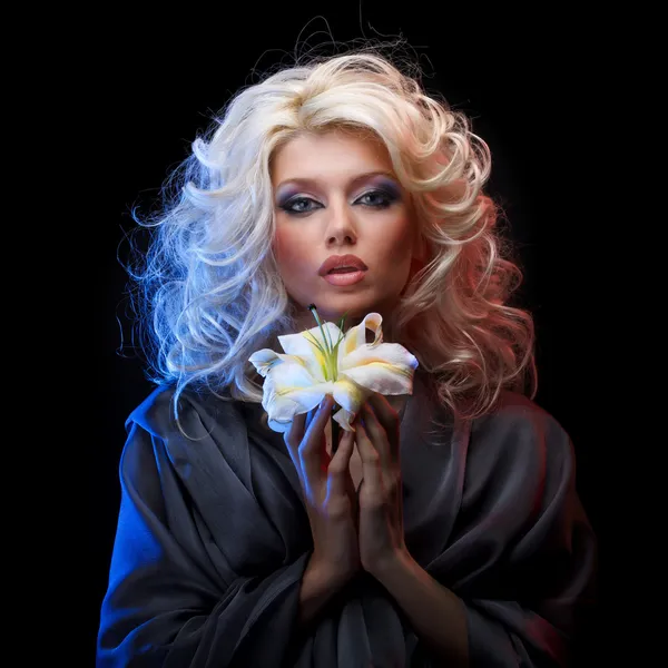 Симпатичная блондинка с голубыми глазами, держащая белую лилию обеими руками — стоковое фото