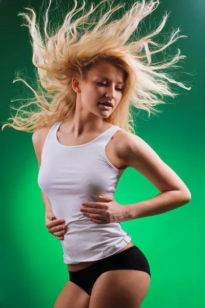 Aantrekkelijke sport blonde met gestreamde haren op groen — Stockfoto