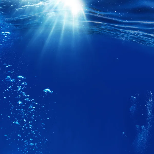 Abstracto azul bajo el agua superficie y burbujas de aire — Foto de Stock