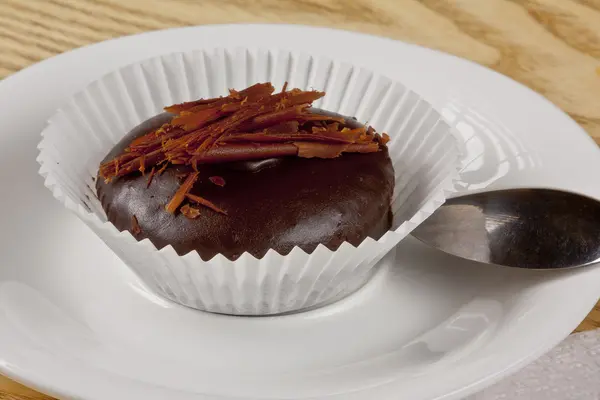 Шоколадный кекс с шоколадной крошкой сверху на белой тарелке — стоковое фото