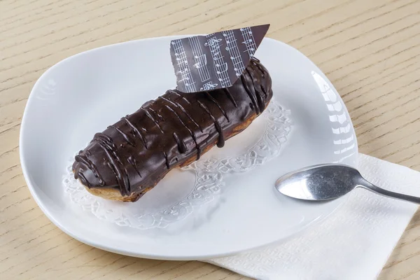 Chocolate eclair on a plate — Stock Photo, Image