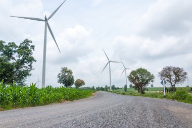 bulutlu gökyüzü karşı güç üreten Rüzgar türbinleri ile yol yol