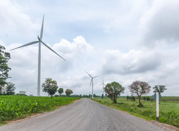 Bulutlu gökyüzü karşı güç üreten Rüzgar türbinleri ile yol yol — Stok fotoğraf
