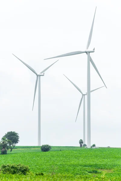 Energiebesparende, windturbines tegen zwaar bewolkt op groen veld — Stockfoto