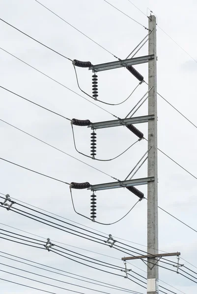 Electricity voltage post with wire on the very cloudy sky Royalty Free Stock Images