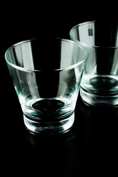 Óculos vazios de uísque em uma superfície reflexiva em fundo preto — Fotografia de Stock