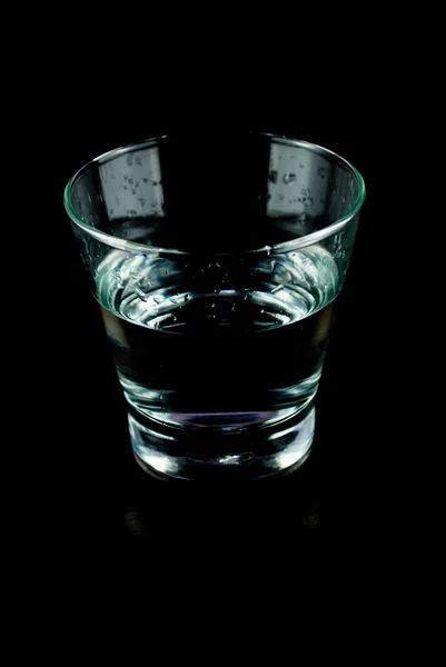 Empty glasses for whiskey on a reflective surface on black background — Stock Photo, Image