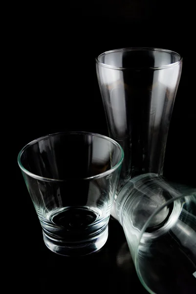 Vasos vacíos para whisky sobre una superficie reflectante sobre fondo negro — Foto de Stock