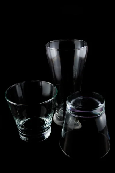 Vasos vacíos para whisky sobre una superficie reflectante sobre fondo negro — Foto de Stock