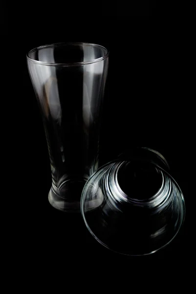 Vasos vacíos para whisky sobre una superficie reflectante sobre fondo negro — Foto de Stock