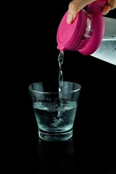 siyah arka plan üzerinde cam-su bir sürahi koy cam sürahi su dökme