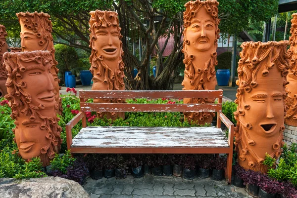 Old wooden bench in the garden with strange decorations. — Stock Photo, Image