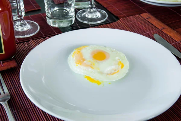 Côté ensoleillé jusqu'à oeuf frit sur plaque blanche sur la table à manger — Photo