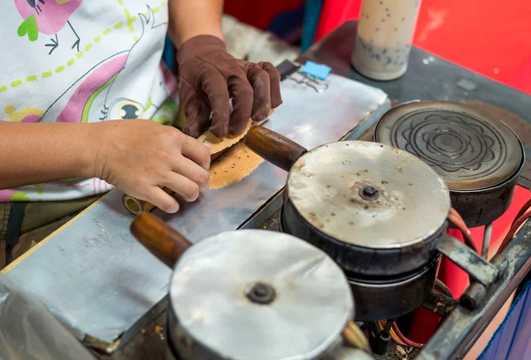 Las mujeres hacen una carne dulce tailandesa (Thong Muan) - Rollos de coco de oro: Snacks tailandeses crujientes Imagen De Stock