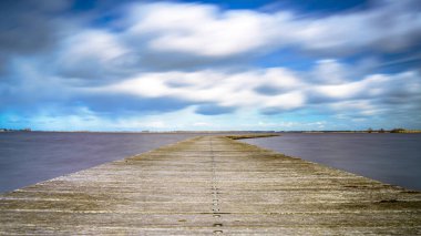 Etkileyici bulutlar ve Hollanda 'da sakin bir göl manzarası. Turizm sezonu başlamadan önce teknelerin iniş noktasında..