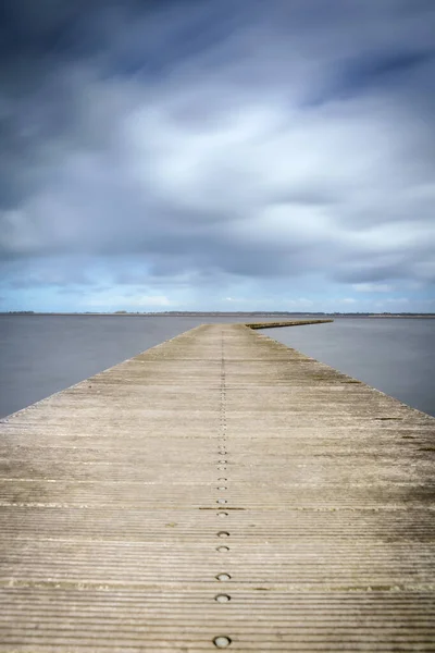 Etkileyici bulutlar ve Hollanda 'da sakin bir göl manzarası. Turizm sezonu başlamadan önce teknelerin iniş noktasında..