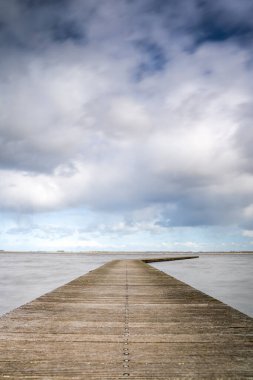 Etkileyici bulutlar ve Hollanda 'da sakin bir göl manzarası. Turizm sezonu başlamadan önce teknelerin iniş noktasında..