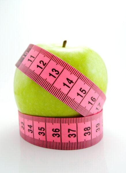 Green apple with pink measuring tape