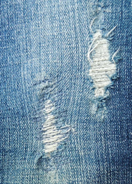Textura jean azul com um buraco e fios mostrando — Fotografia de Stock