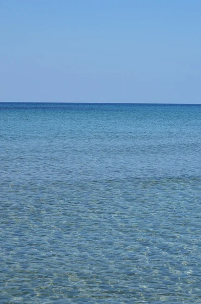 Mar azul com ondas e céu azul claro — Fotografia de Stock