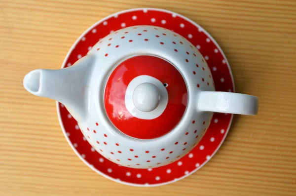Rode polka dot ketel op houten tafel — Stockfoto