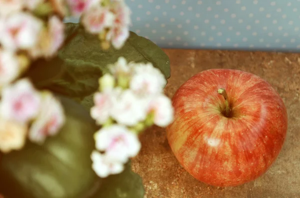 Pomme sur les vieux livres et les fleurs — Photo