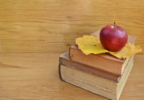 Apfel auf alten Büchern auf Holzgrund — Stockfoto