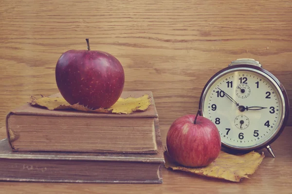 Παλιό ρολόι καφέ με μήλα και βιβλία — Φωτογραφία Αρχείου