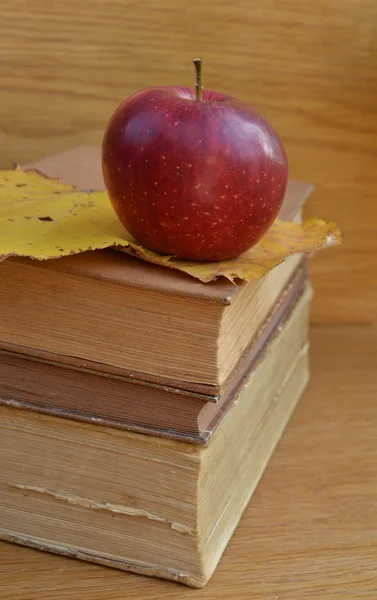 Красное яблоко на старых книгах — стоковое фото