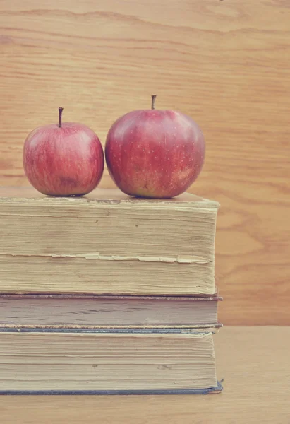 Bücherstapel und roter Apfel auf Holztisch — Stockfoto