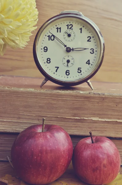 Libros de época con reloj y manzanas — Foto de Stock