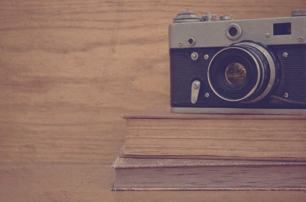 Cámara vintage en libro sobre fondo de madera —  Fotos de Stock