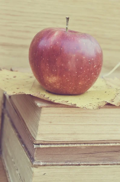 Frischer roter Apfel auf alten Büchern — Stockfoto