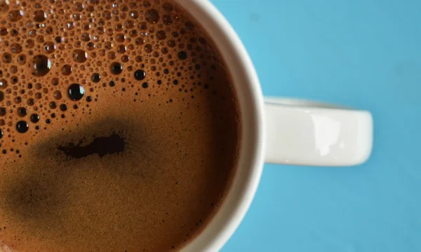 Kopje zwarte koffie op blauwe achtergrond — Stockfoto