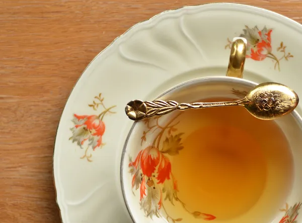 Taza de té y cucharadita en madera — Foto de Stock