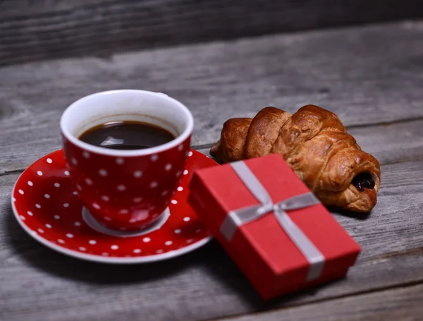 Cup of coffee with present and croissant on wooden — Stock Photo, Image