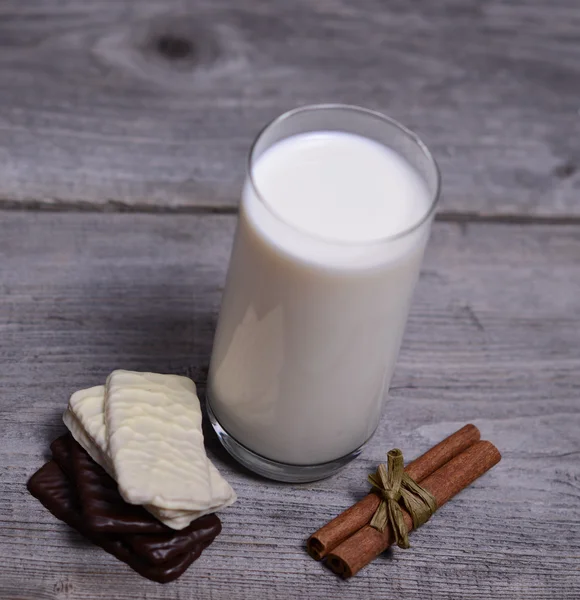 Glass of milk with cinnamon and chocolate cookies — Stock Photo, Image