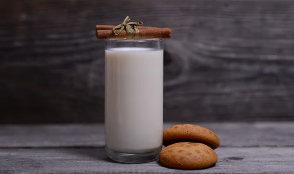 Glass of milk with cinnamon and gingerbread on wooden — Stock Photo, Image