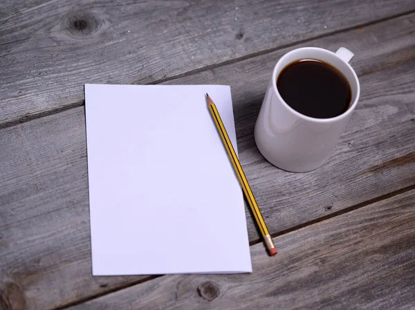 Witte mok van koffie en blanco papier — Stockfoto