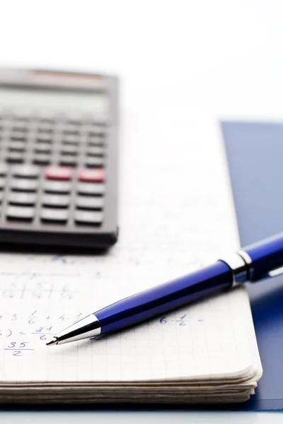 Scientific calculator, a blue-silver pen on the marhs workbook — Stock Photo, Image